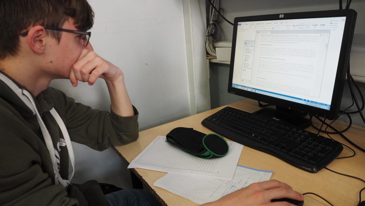 Aluno concentrado na sala de informática